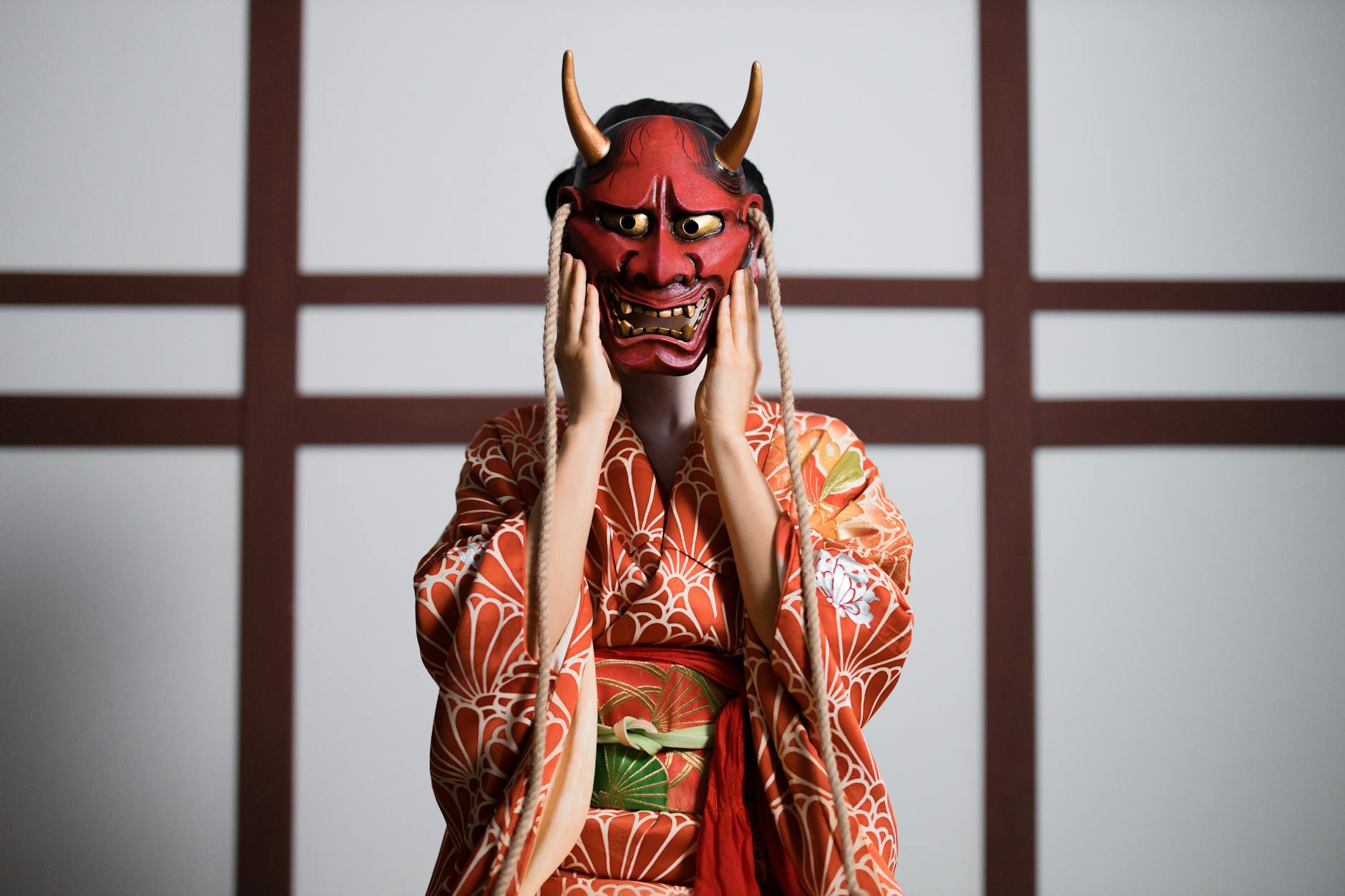 a person in a kimono wearing a hannya mask
