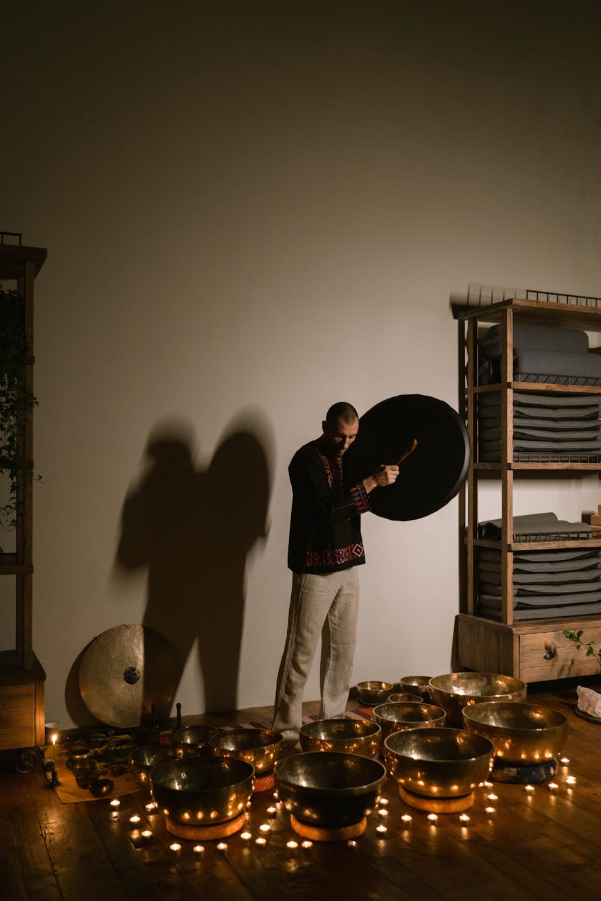 a man standing beside the singing bowls